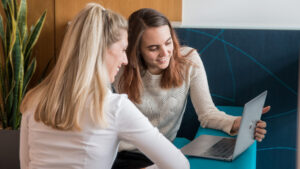 Zwei OCG Mitarbeiterinnen sehen auf Laptop