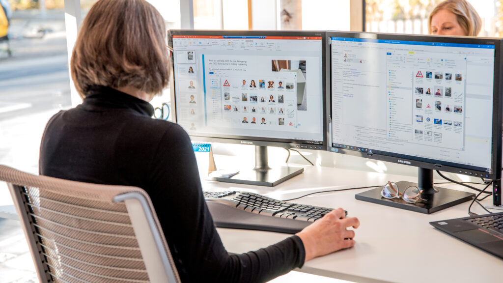 OCG Mitarbeiterinnen arbeiten in Büro an PC mit zwei Bildschirmen