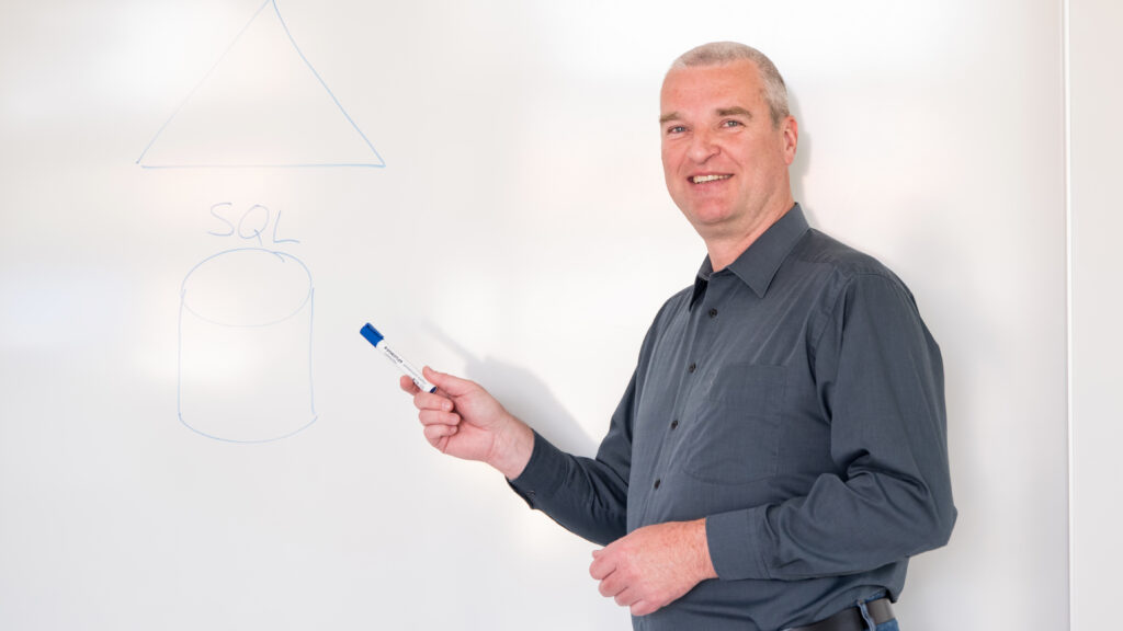 OCG Mitarbeiter zeigt Traingsteilnehmern etwas auf Whiteboard